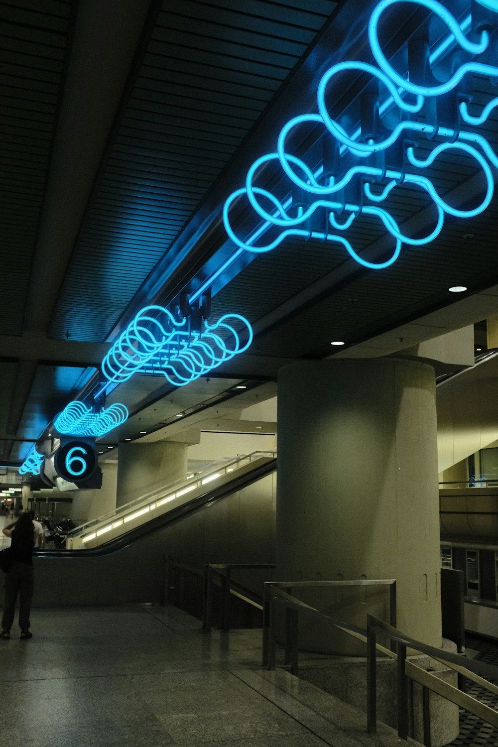 a man is standing in a large building with blue lights