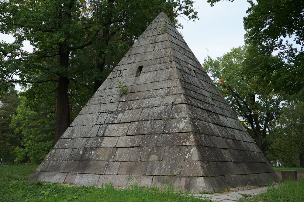 a large stone pyramid sitting in the middle of a forest