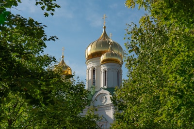 Historic Orthodox churches with golden domes shining under a clear sky in Russia.