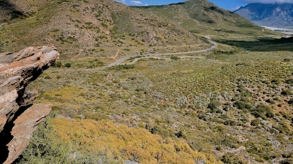 a scenic view of a winding road in the mountains