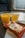 Two plastic cups filled with orange juice are placed on a tray table. Alongside them, there are packets of cookies, with one labeled as salted caramel flavored. The setting appears to be on a train, with a window and seat visible in the background.