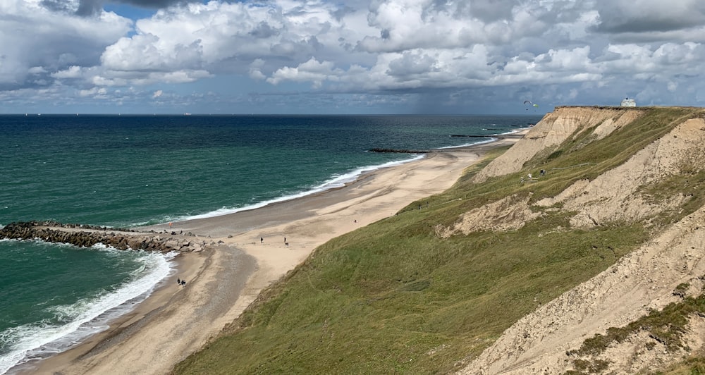 a view of a sandy beach and ocean from a cliff