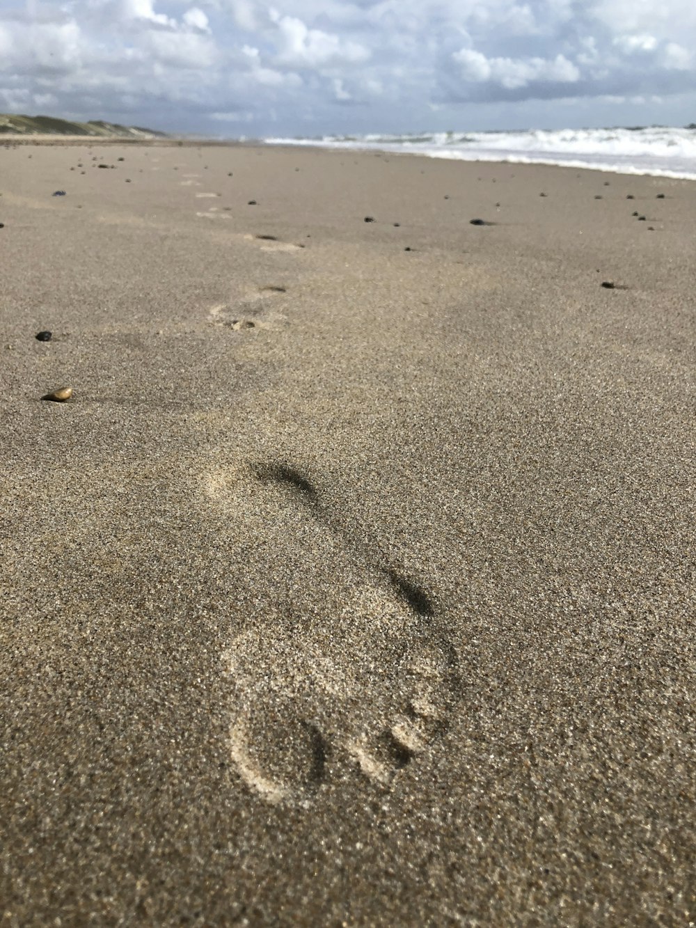 a person's footprints in the sand on a beach