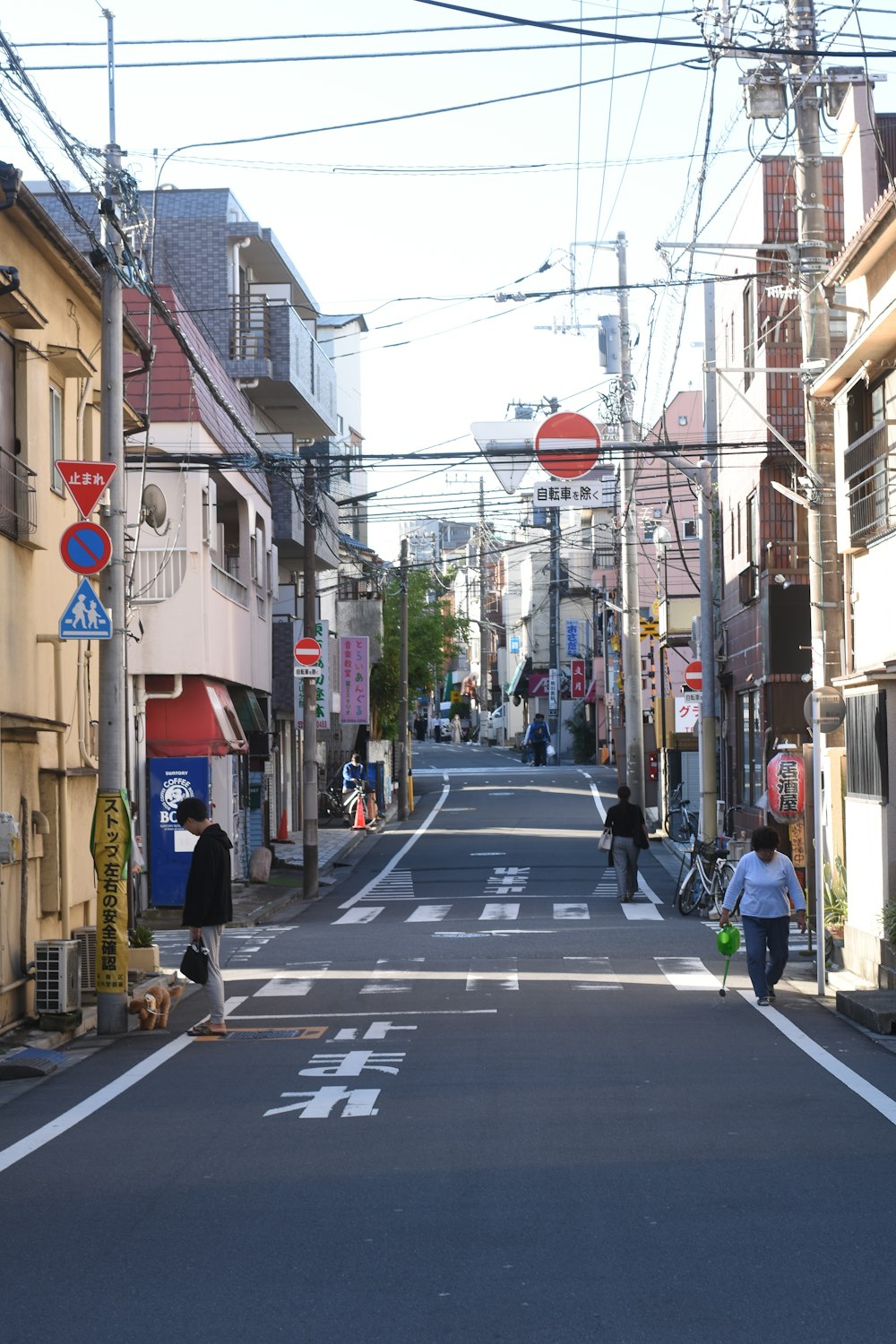 a street with a few people walking down it