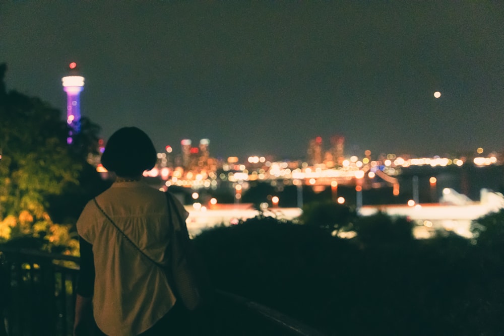 a person looking at a city at night