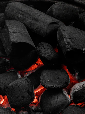 Close-up of glowing metallurgical coke pieces ready for shipment in an industrial warehouse.