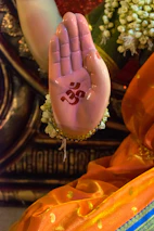 A close-up of Emelia's hands holding a symbol of her heritage, surrounded by vibrant fabric.