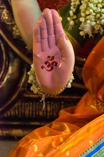 Hands raised with intricate signs as part of a church ritual.