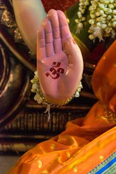 A close-up of Emelia's hands holding a symbol of her heritage, surrounded by vibrant fabric.