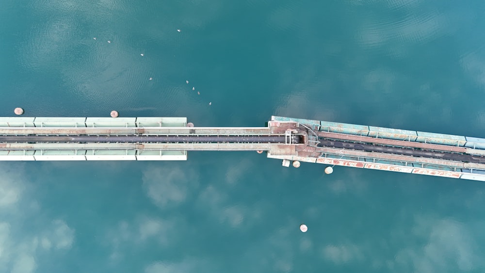 an aerial view of a train crossing a bridge over water