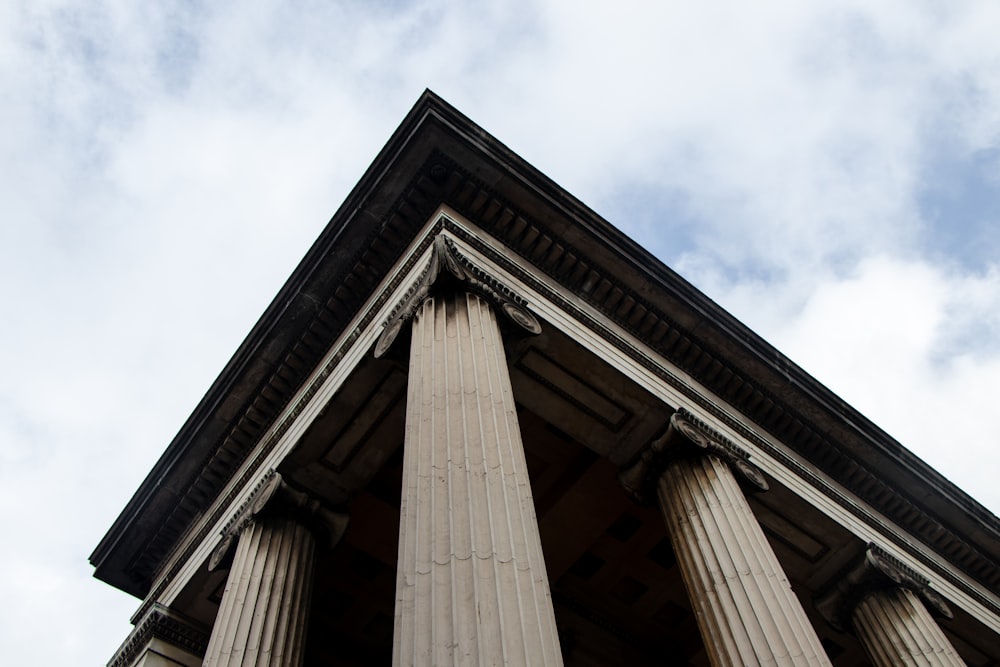 the top of a building with columns and a sky background