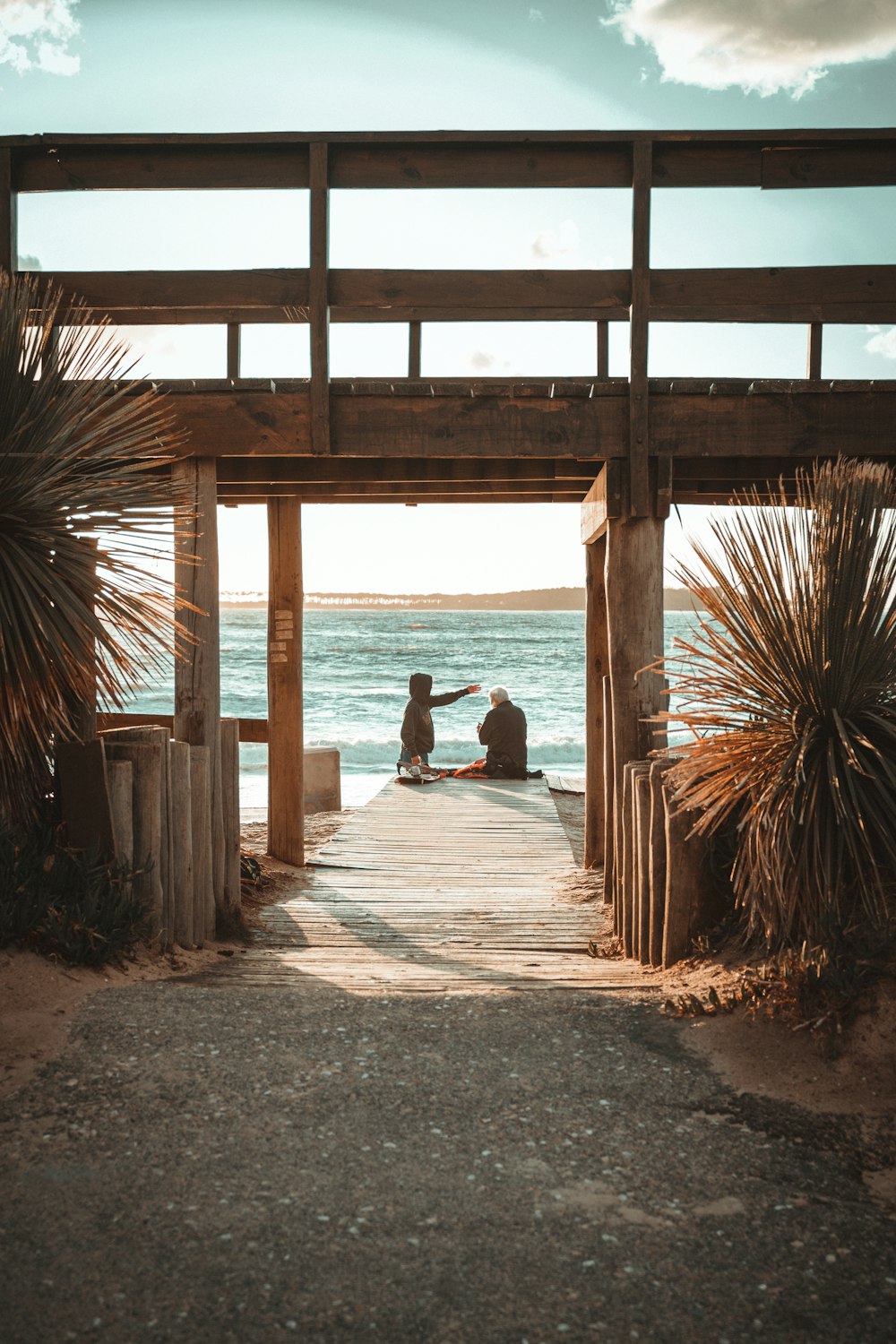 Un par de personas sentadas en lo alto de un muelle