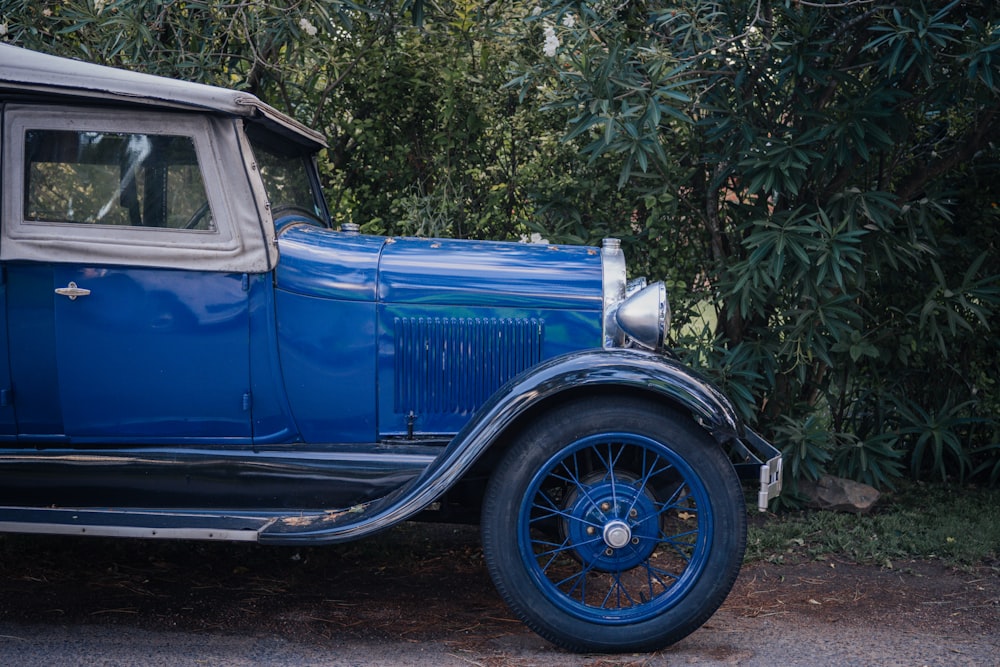 Un viejo coche azul aparcado a un lado de la carretera