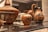 A collection of ancient pottery items displayed in a museum setting, featuring intricate designs and patterns. The pottery includes a large bowl with a lid, a small vase, and a jug, all adorned with animal motifs and floral patterns.