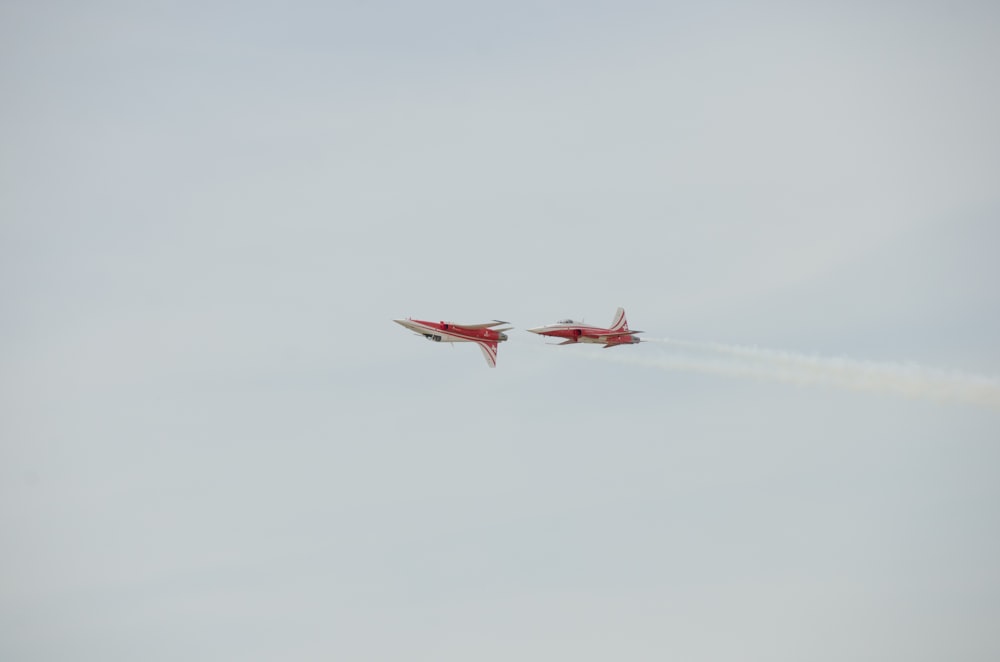 two red and white jets flying in the sky