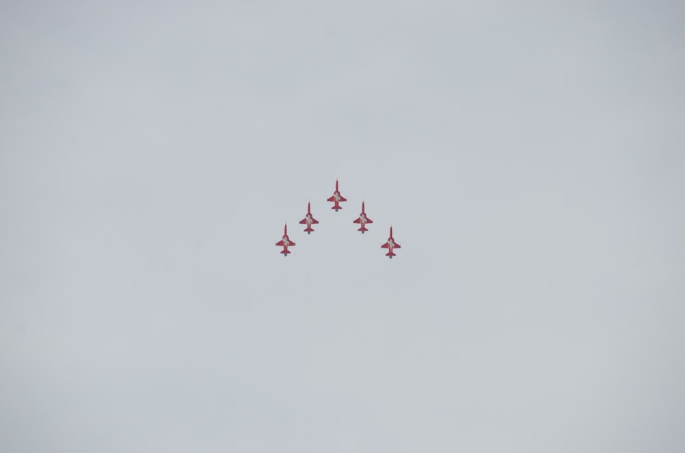 Un grupo de aviones de combate volando a través de un cielo nublado