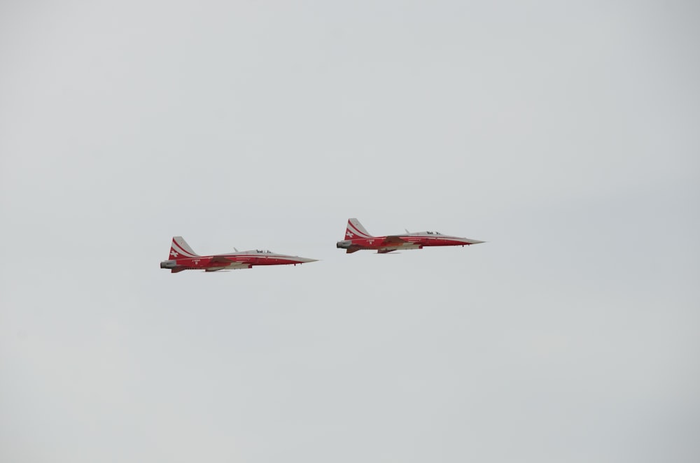 two red and white jets flying in the sky