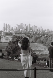 A stylish woman wearing a flowing dress in a city park.