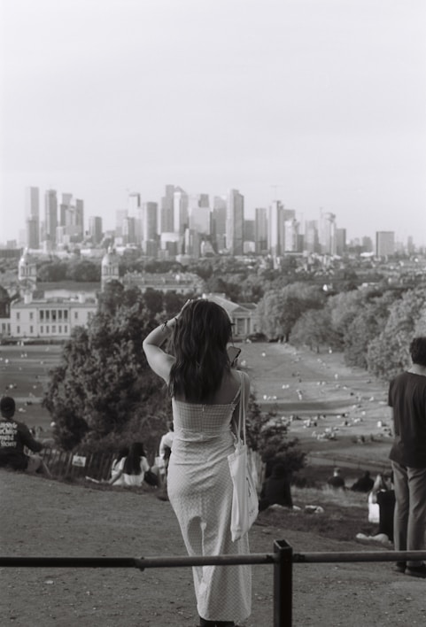 A stylish woman wearing a flowing dress in a city park.