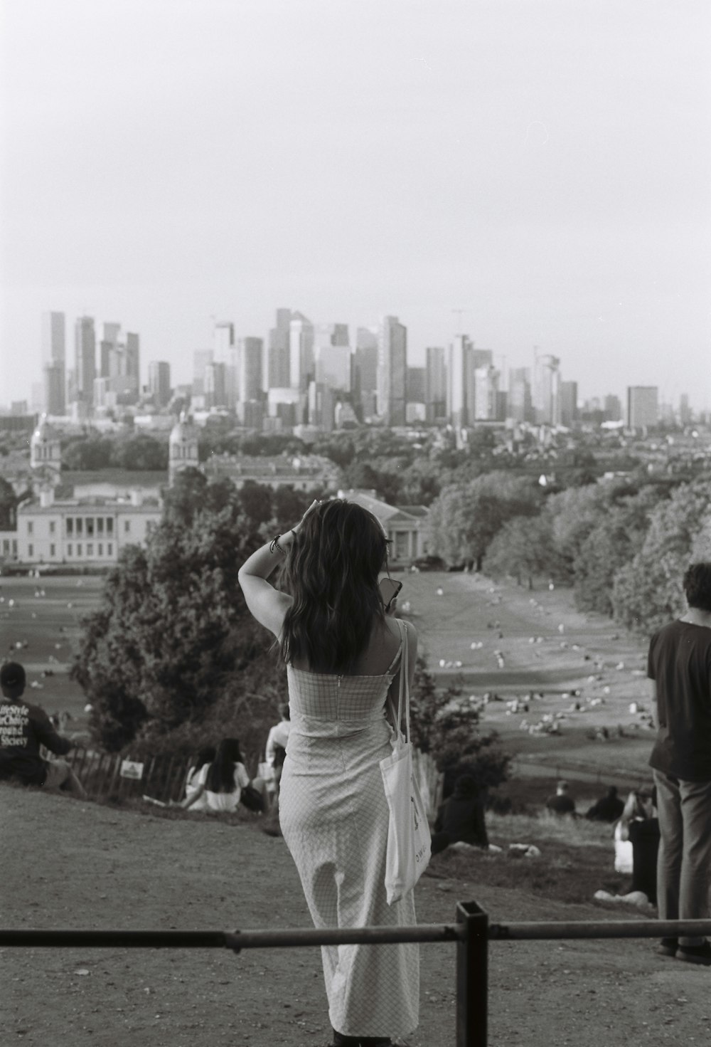 a woman standing on top of a lush green hillside