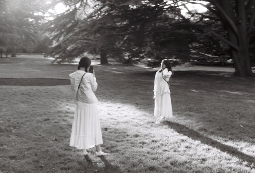 A professional photographer capturing a couple in a park.
