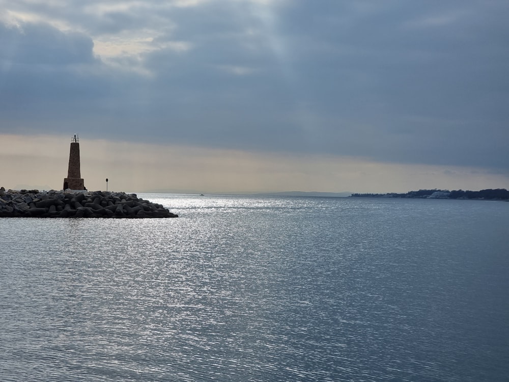 a lighthouse on a small island in the middle of the ocean