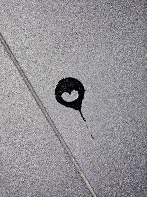 A blood-red stain spreading across a cracked concrete floor, symbolizing hidden violence.