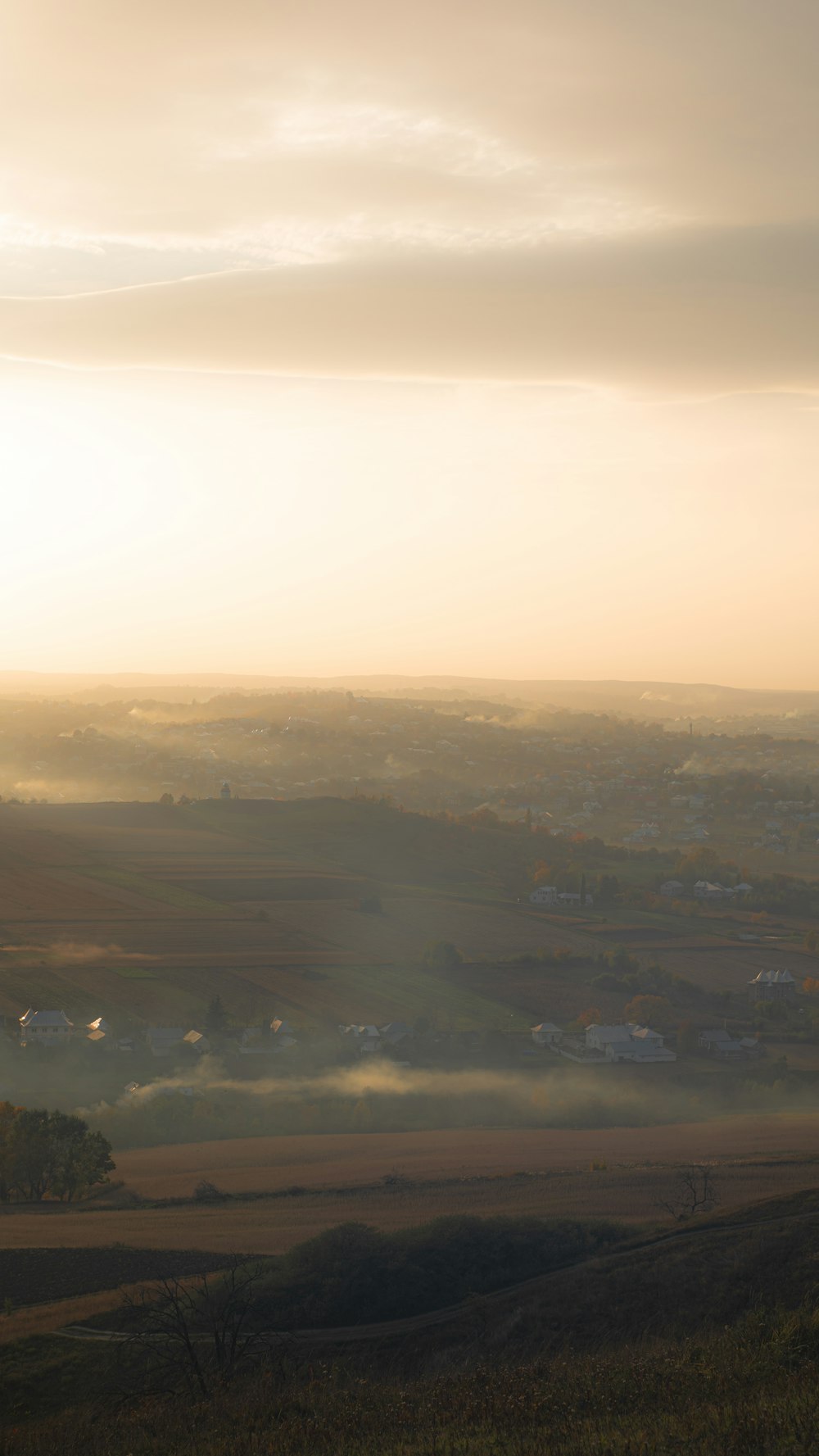 Una vista de un valle brumoso desde una colina