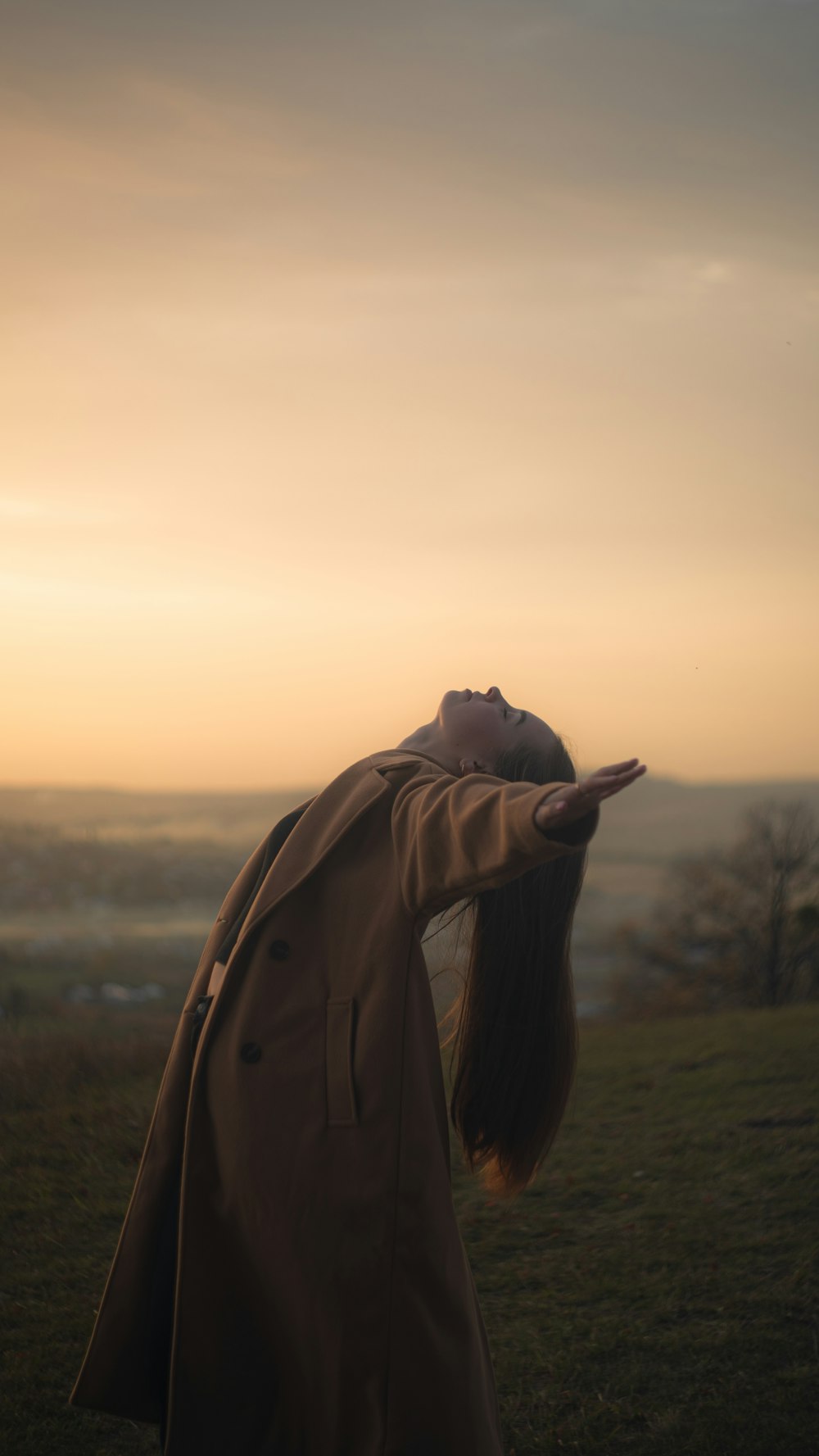 a woman with long hair standing in a field