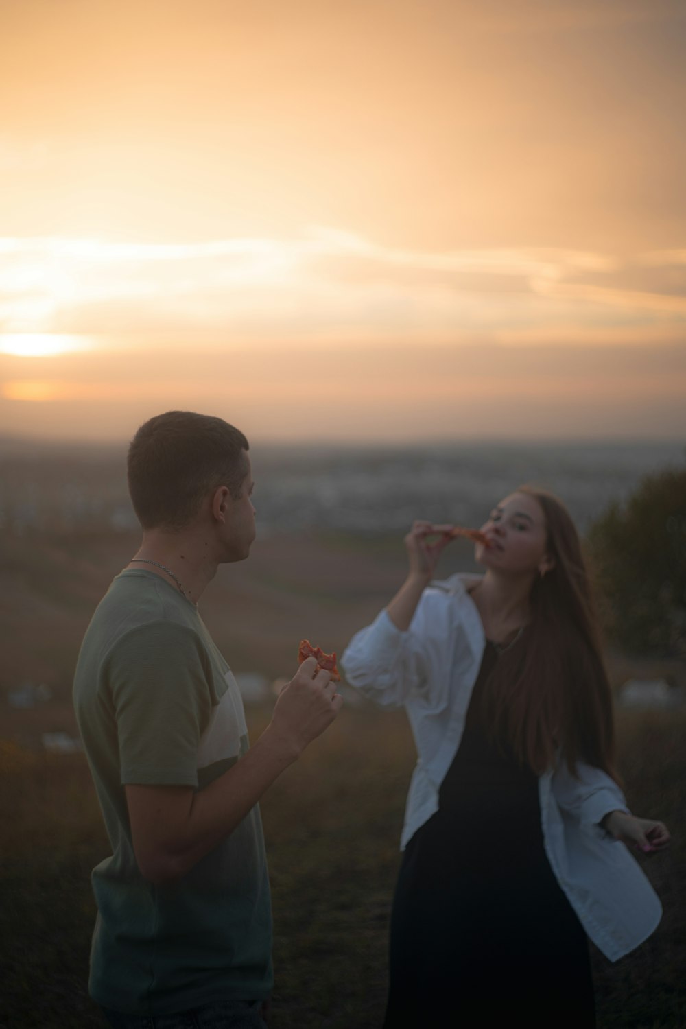 a man standing next to a woman in a field