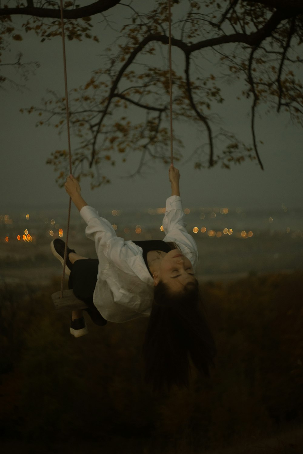 a woman is swinging on a tree swing