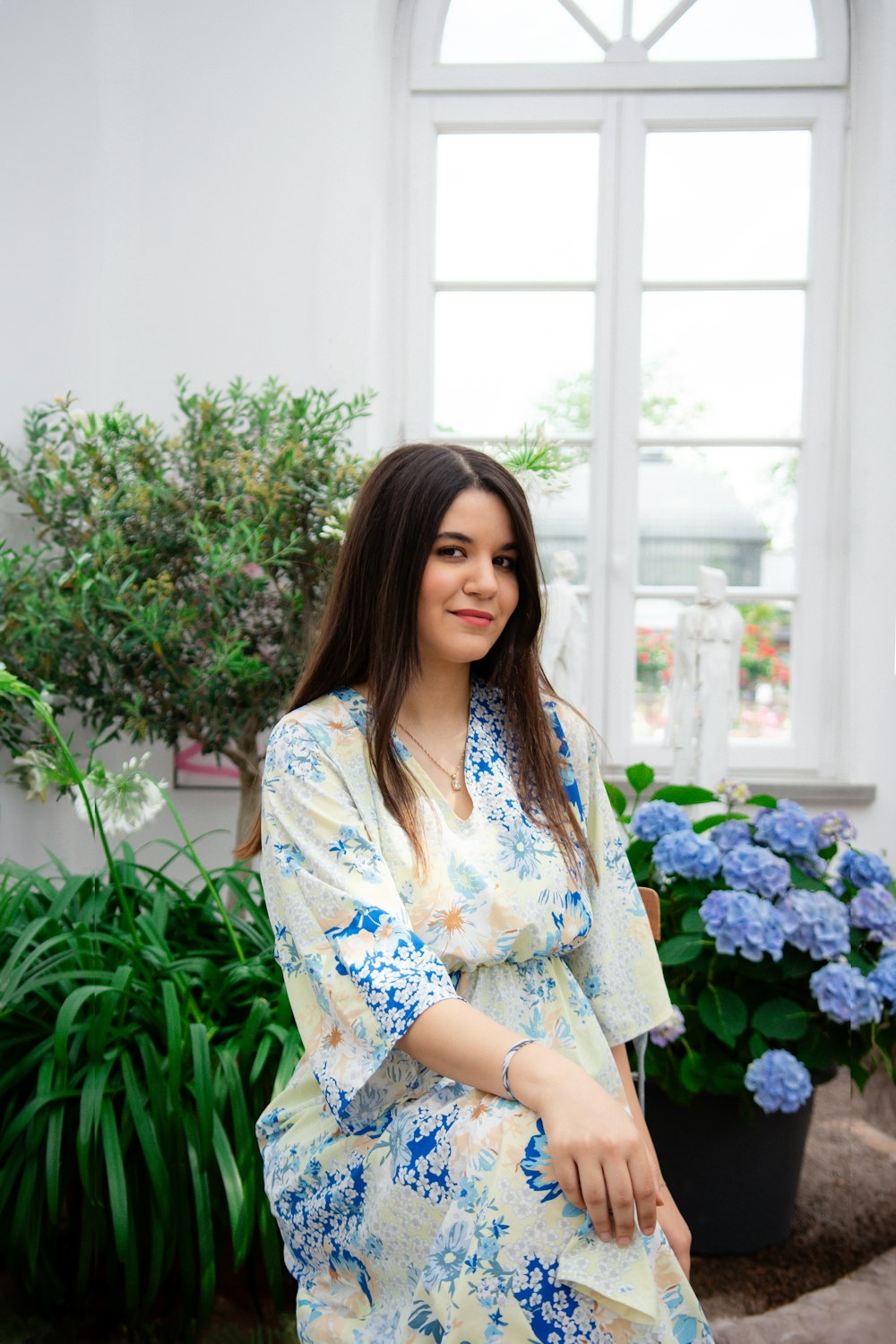 a woman standing in front of a potted plant