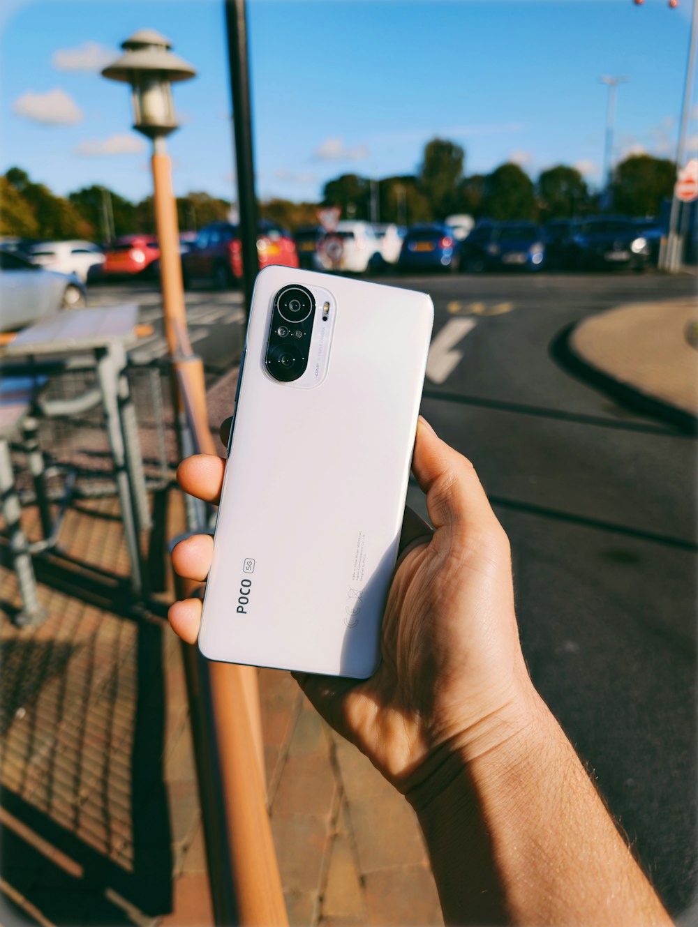 a person holding a white cell phone in their hand