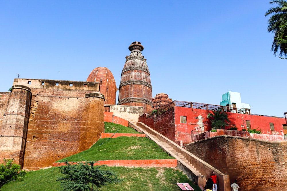 a very tall tower sitting on top of a lush green hillside