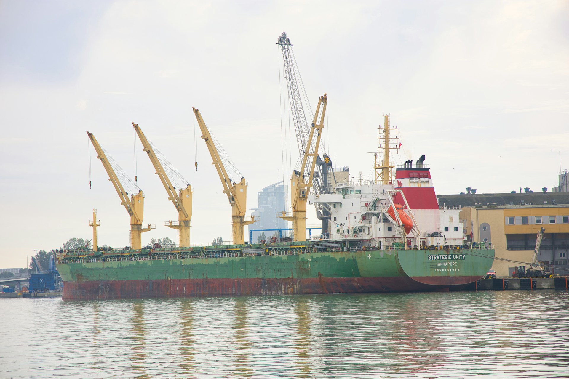 a large green and white ship in a body of water