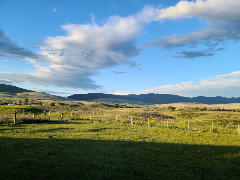 a grassy field with mountains in the distance