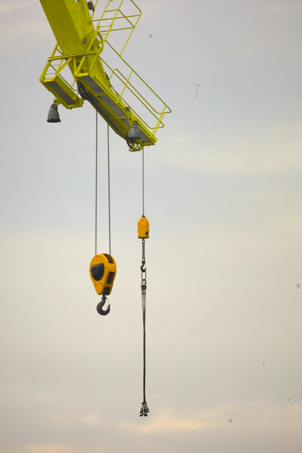 a yellow crane is lifting a yellow object into the air