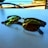 A pair of sunglasses with reflective lenses sits on a white surface, capturing the scenic view of a beach in the background. The lenses reflect the blue sky and some greenery. The table seems to be located outdoors, near a coastal area with a railing visible in the background.
