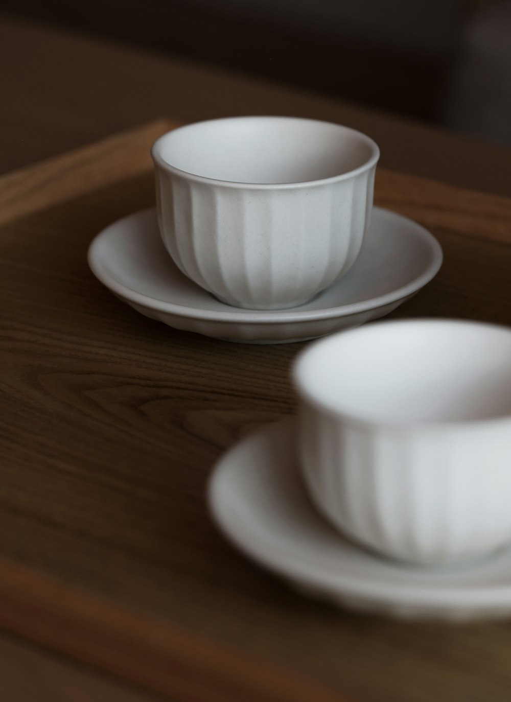a couple of white dishes sitting on top of a wooden table