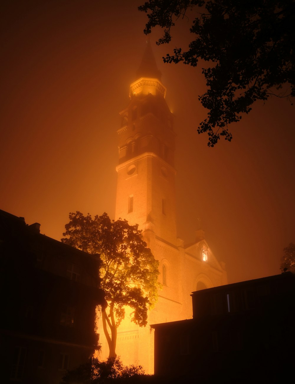 uma torre de relógio alta elevando-se sobre uma cidade à noite