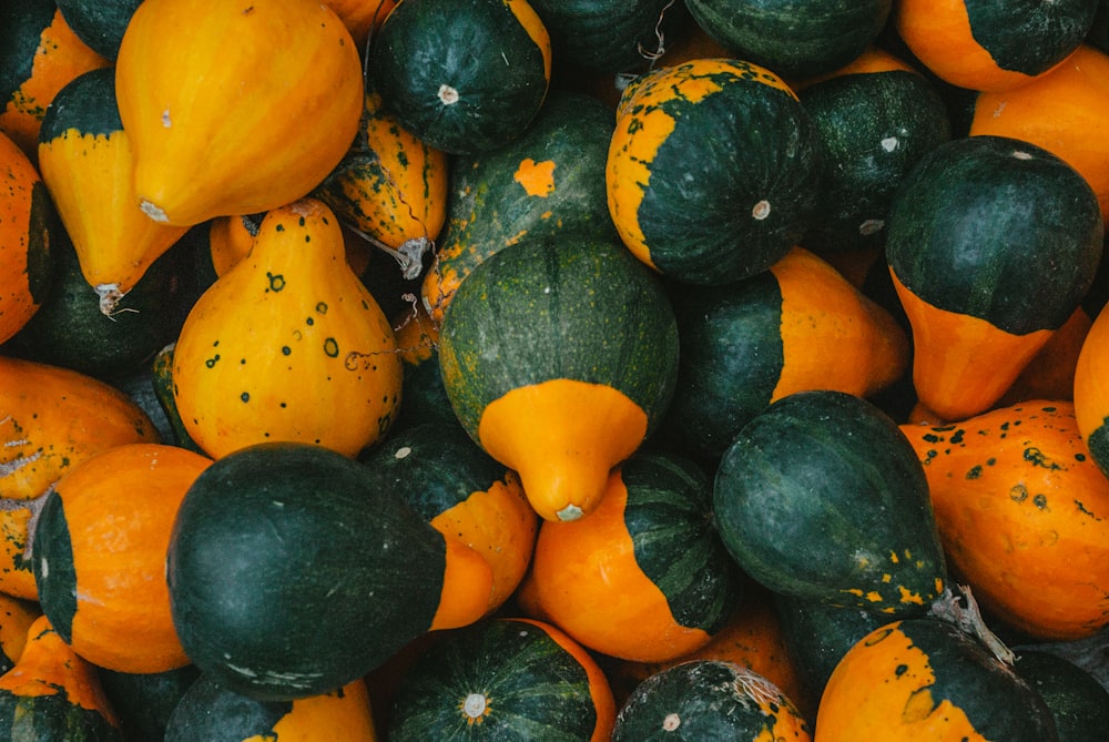 a pile of orange and green gourds sitting next to each other