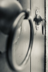 Close-up of hands installing decorative hardware on a door.