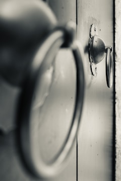 Close-up of hands installing decorative hardware on a door.
