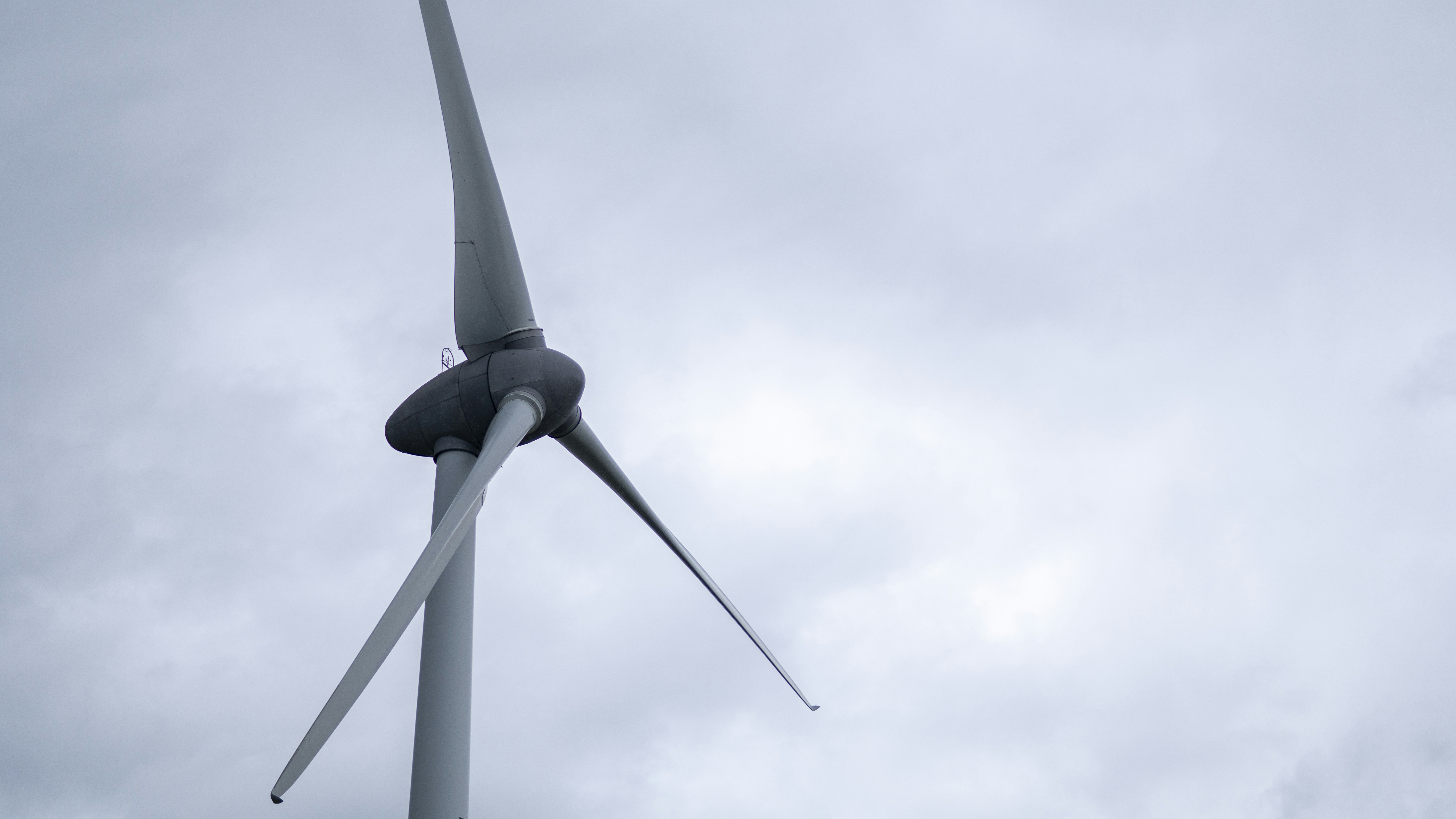a wind turbine is shown against a cloudy sky
