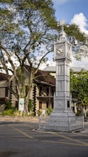 a tall clock tower sitting on the side of a road