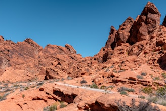 A vast desert landscape with red rock formations under a clear blue sky.