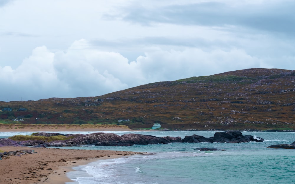 a sandy beach next to a body of water