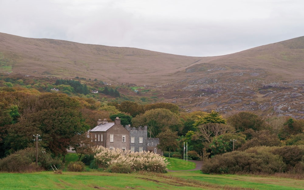 a house sitting in the middle of a lush green field