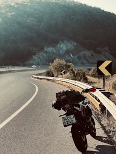 Motorcycle being carefully loaded onto a rescue truck at roadside during daylight.