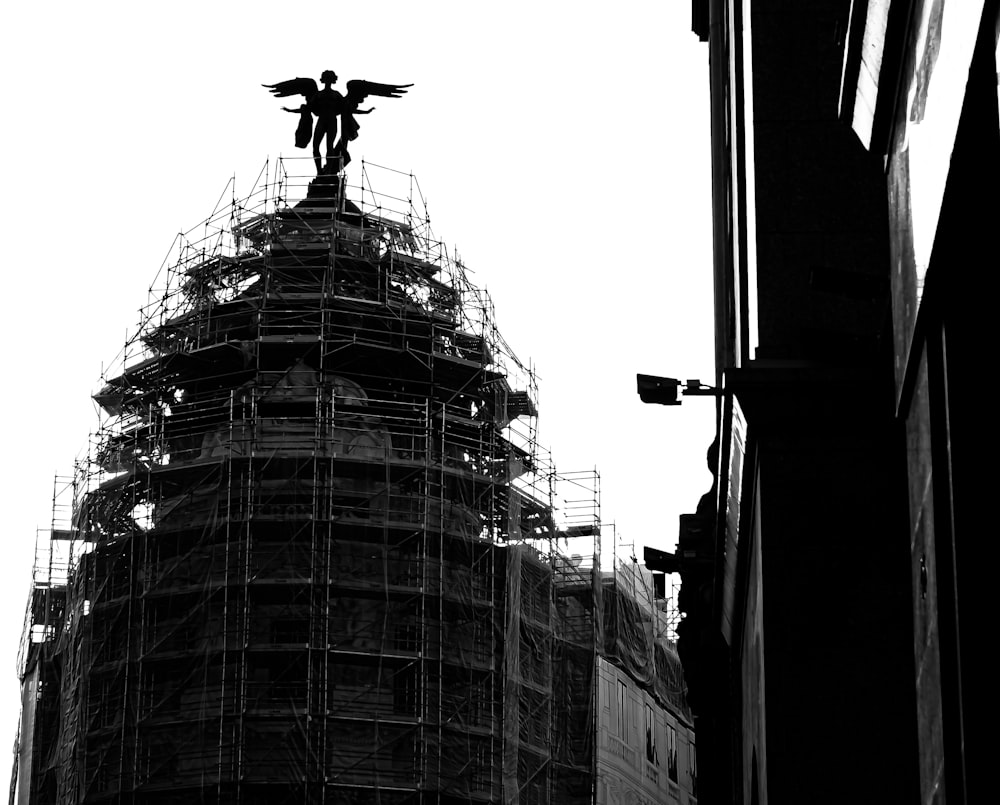 une photo en noir et blanc d’un bâtiment avec échafaudage